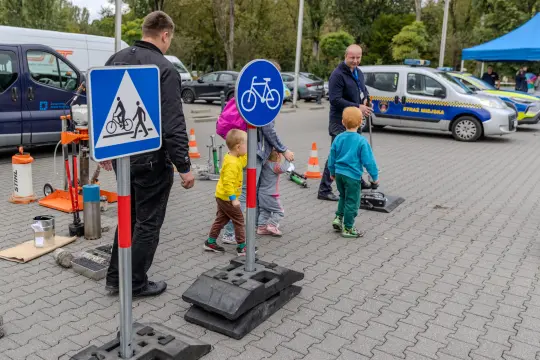 Dzieci uczą się zasad ruchu drogowego przy znakach drogowych.