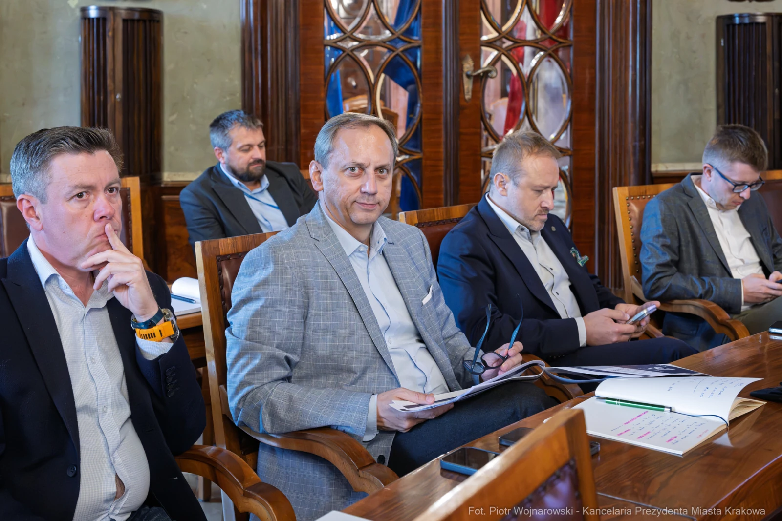 Grupa mężczyzn w garniturach siedzących przy stole, uczestniczących w spotkaniu.  Autor: Piotr Wojnarowski