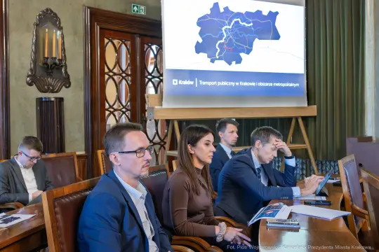 Spotkanie dotyczące transportu publicznego w Krakowie, uczestnicy przy stole.
