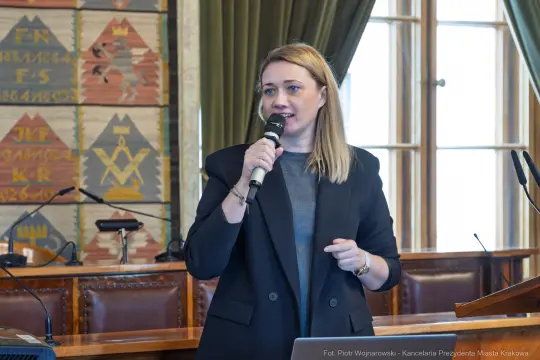 Kobieta z mikrofonem przemawia w sali konferencyjnej.