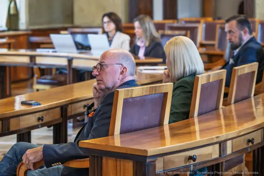 Grupa osób w sali obrad, skupionych na dyskusji.