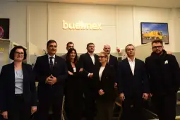 Grupa osób w biurze Budimex, w tle logo firmy.