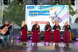 Zespół muzyczny w tradycyjnych strojach występuje na scenie podczas festiwalu w Krakowie.