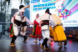 Tradycyjny taniec ludowy w kolorowych strojach na festiwalu w Krakowie.