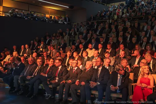 Tłum ludzi siedzących na widowni podczas wydarzenia.