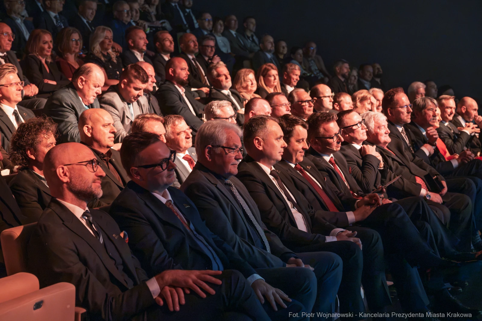 Grupa mężczyzn w garniturach siedzących na widowni podczas wydarzenia.  Autor: Piotr Wojnarowski
