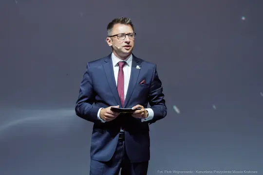 Mężczyzna w garniturze przemawia do publiczności.