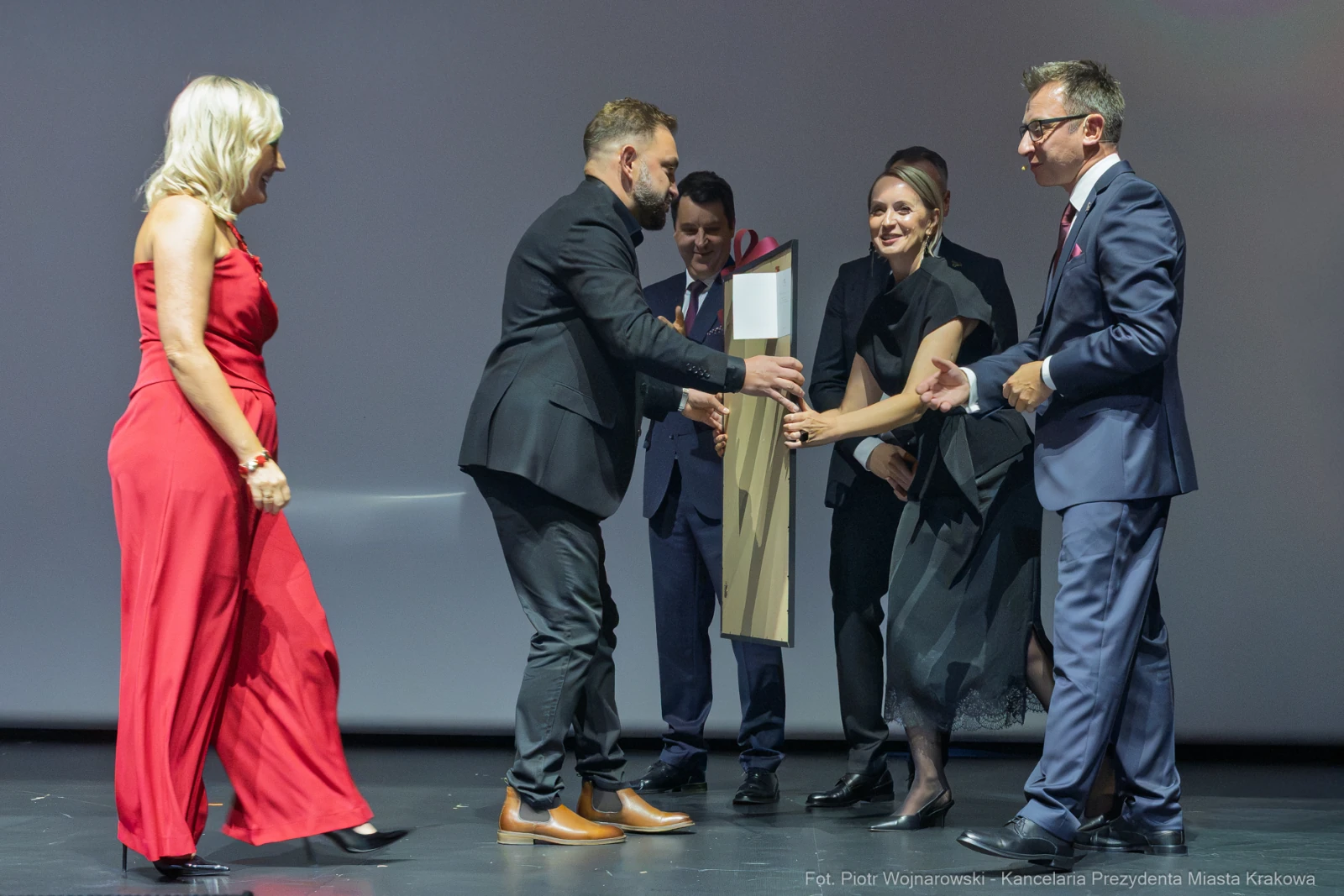 Wręczenie nagrody podczas uroczystości, uczestnicy w eleganckich strojach.  Autor: Piotr Wojnarowski