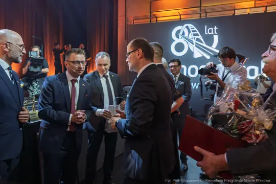 Uroczystość z okazji 80-lecia, wręczenie nagród i gratulacje w eleganckiej scenerii.