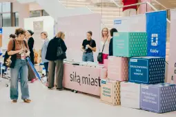 Stoiska promocyjne z materiałami informacyjnymi o Krakowie i lokalnych inicjatywach.
