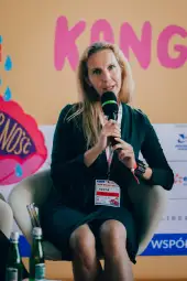 Kobieta z mikrofonem, prowadząca dyskusję na konferencji.