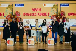 Uczestniczki XVIII Kongresu Kobiet na scenie, z kwiatami i nagrodami.