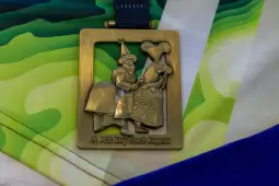 Medal z wizerunkiem postaci w strojach ludowych, z napisem 12. PGE Bieg Trzech Kopców.
