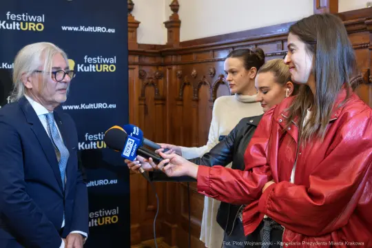 Wywiad z mężczyzną w okularach, w tle logo festiwalu KultURO.