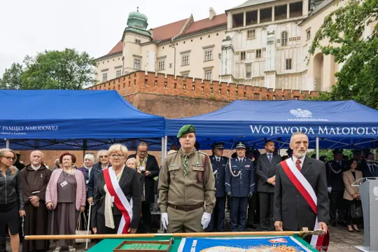 Uroczystość z udziałem wojskowych i przedstawicieli władz w tle zamek.