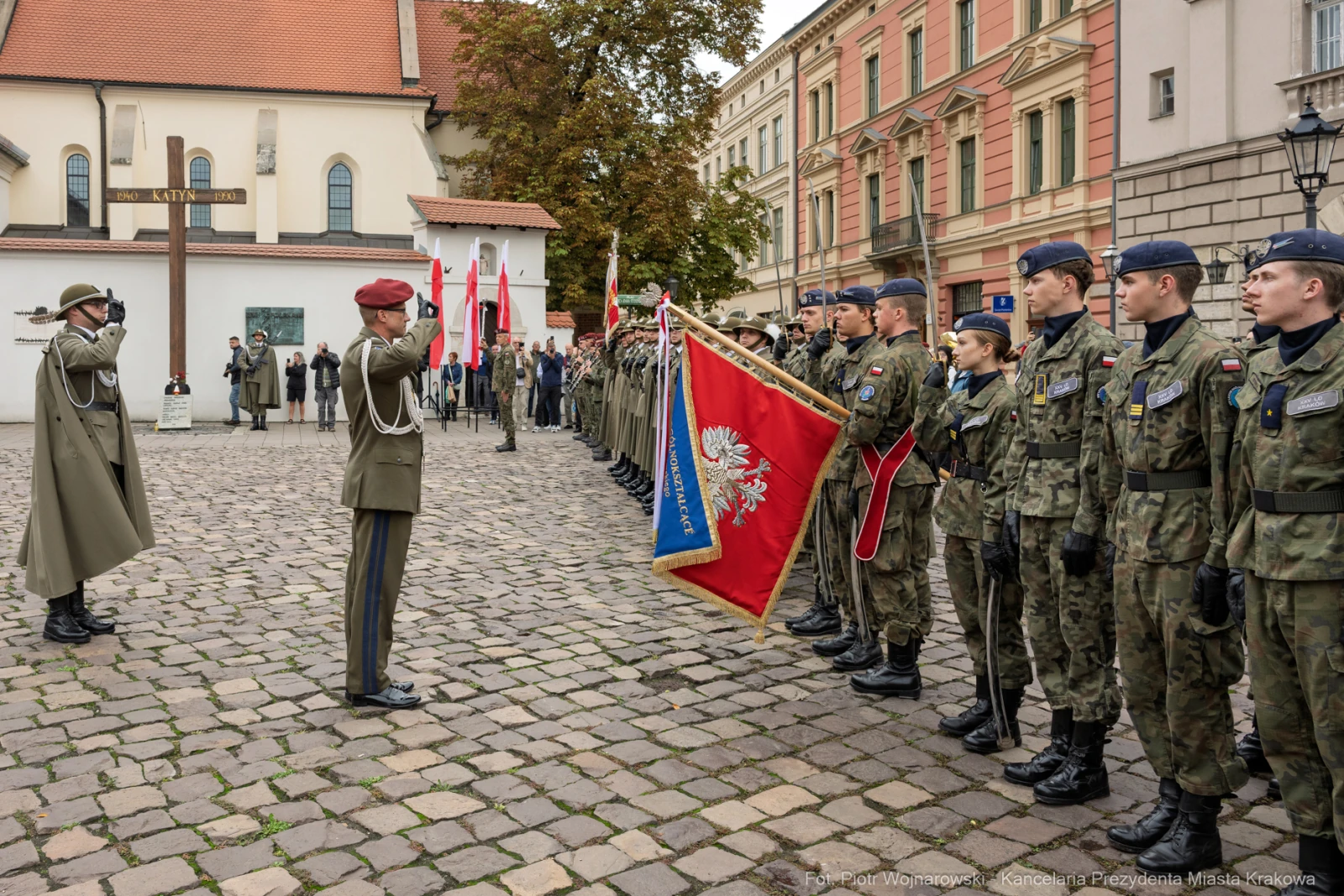 Ceremonia wojskowa z żołnierzami, sztandarami i flagami w historycznej scenerii.  Autor: Piotr Wojnarowski