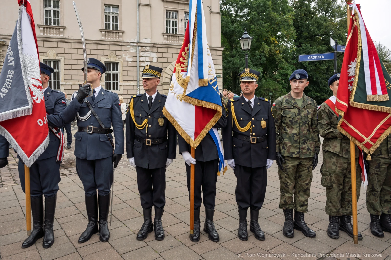 Grupa mężczyzn w mundurach, trzymających sztandary, podczas uroczystości.  Autor: Piotr Wojnarowski