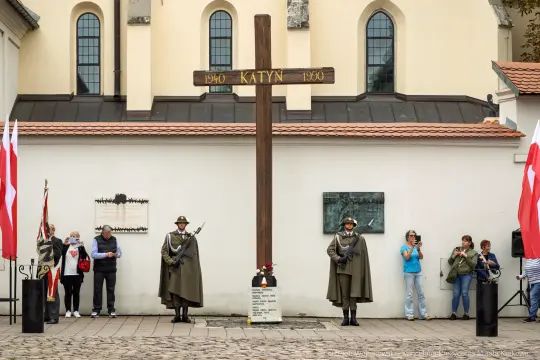 Uroczystość upamiętniająca ofiary Katynia z wartą honorową i flagami.
