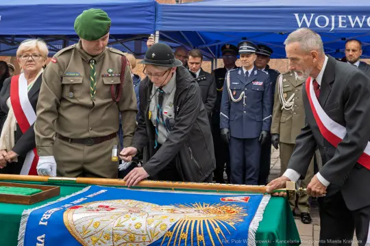 Uroczystość z udziałem wojskowych i cywilnych przedstawicieli przy odsłonięciu sztandaru.