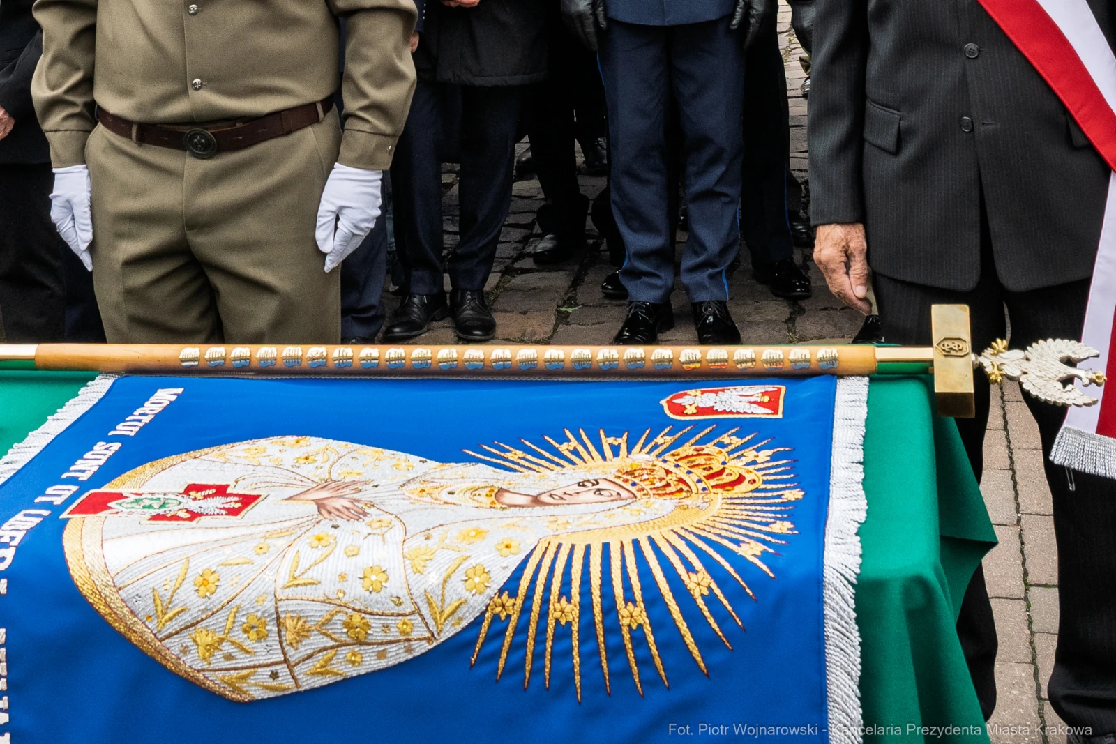 Sztandar z wizerunkiem Matki Boskiej i herbem, trzymany przez żołnierzy podczas ceremonii.  Autor: Piotr Wojnarowski