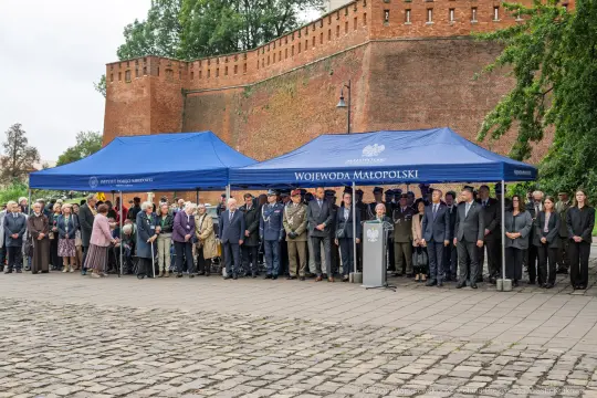 Uroczystość z udziałem wielu osób pod namiotami, przemówienie przy mównicy.