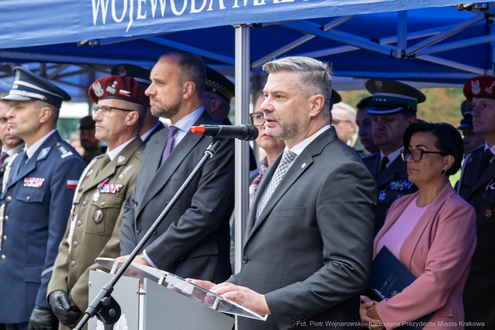 Mężczyzna przemawia do zgromadzonego tłumu, w tle przedstawiciele służb mundurowych.  Autor: Piotr Wojnarowski