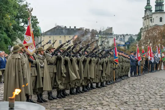 Uroczystość wojskowa z żołnierzami w mundurach, oddający salwę honorową.