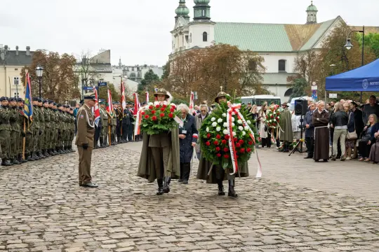 Uroczystość złożenia wieńców na cześć bohaterów, obecność żołnierzy i mieszkańców.