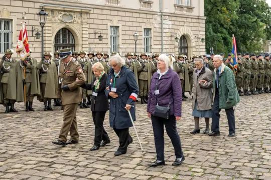 Uroczystość z udziałem weteranów i żołnierzy, z flagami i mundurami wojskowymi.