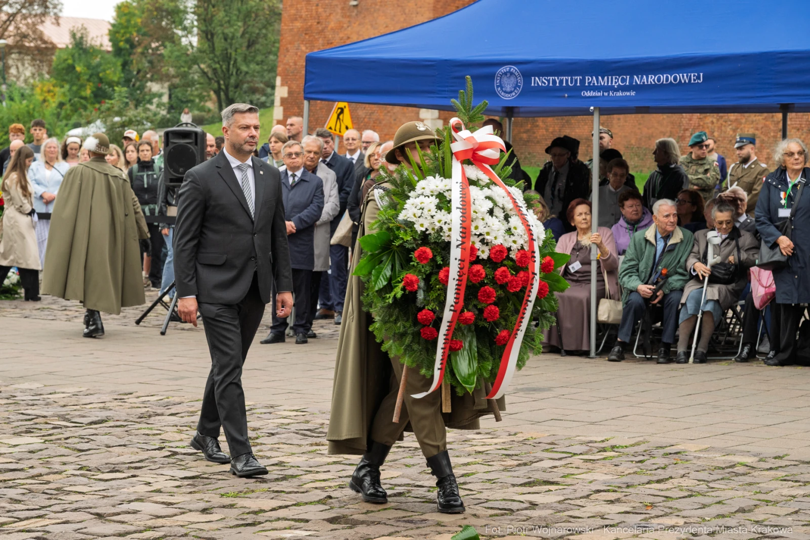 Ceremonia składania wieńca z kwiatów w hołdzie zmarłym, obecność uczestników i przedstawicieli instytucji.  Autor: Piotr Wojnarowski