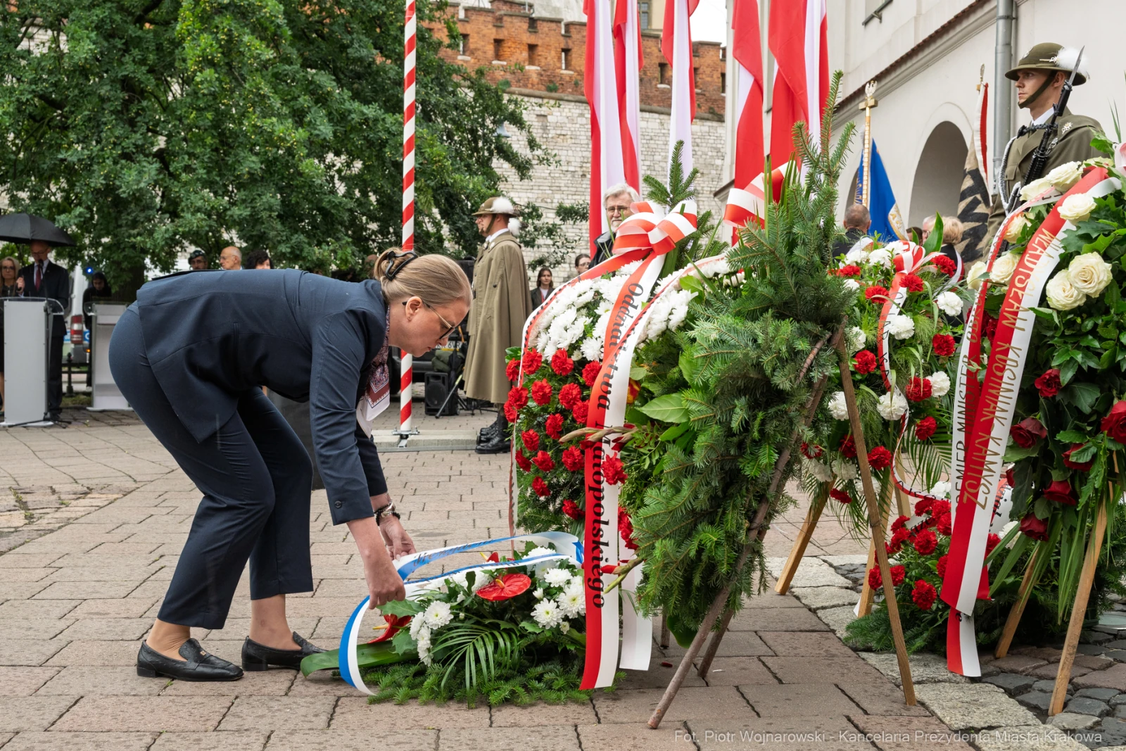 Kobieta składa wieniec na uroczystości upamiętniającej.  Autor: Piotr Wojnarowski