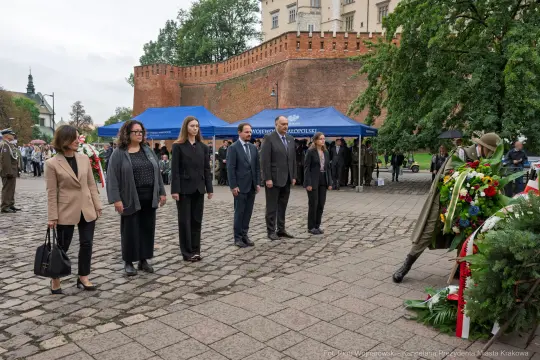 Uroczystość złożenia wieńców przed pomnikiem, obecność przedstawicieli władz i rodzin.