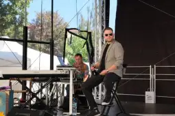 Muzycy na scenie, jeden przy fortepianie, drugi siedzący z mikrofonem.