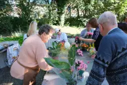 Osoby tworzące bukiety kwiatów w ogrodzie.