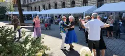 Seniorzy tańczą na świeżym powietrzu podczas wydarzenia towarzyskiego.