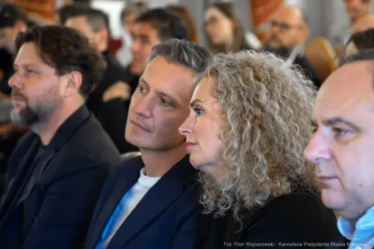 Grupa osób w trakcie wydarzenia, skupionych na prezentacji.