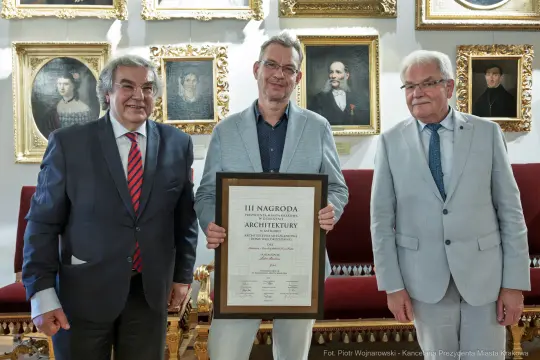 Trzech mężczyzn z dyplomem nagrody za architekturę.