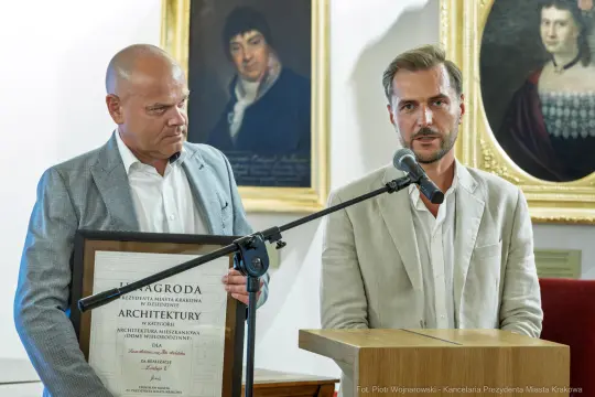 Wręczenie nagrody za architekturę, dwóch mężczyzn z dyplomem w ręku.