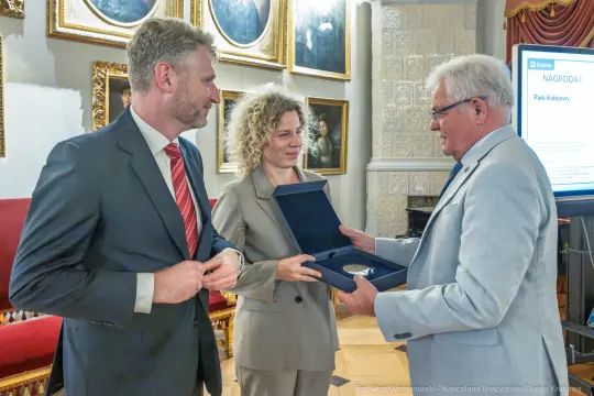 Wręczenie nagrody w Parku Kościuszki, trzej uczestnicy ceremonii z medalem.