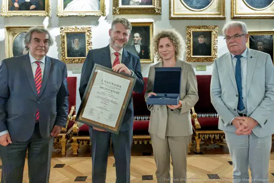 Wręczenie nagrody za osiągnięcia w architekturze. Czworo ludzi z dyplomem i statuetką.