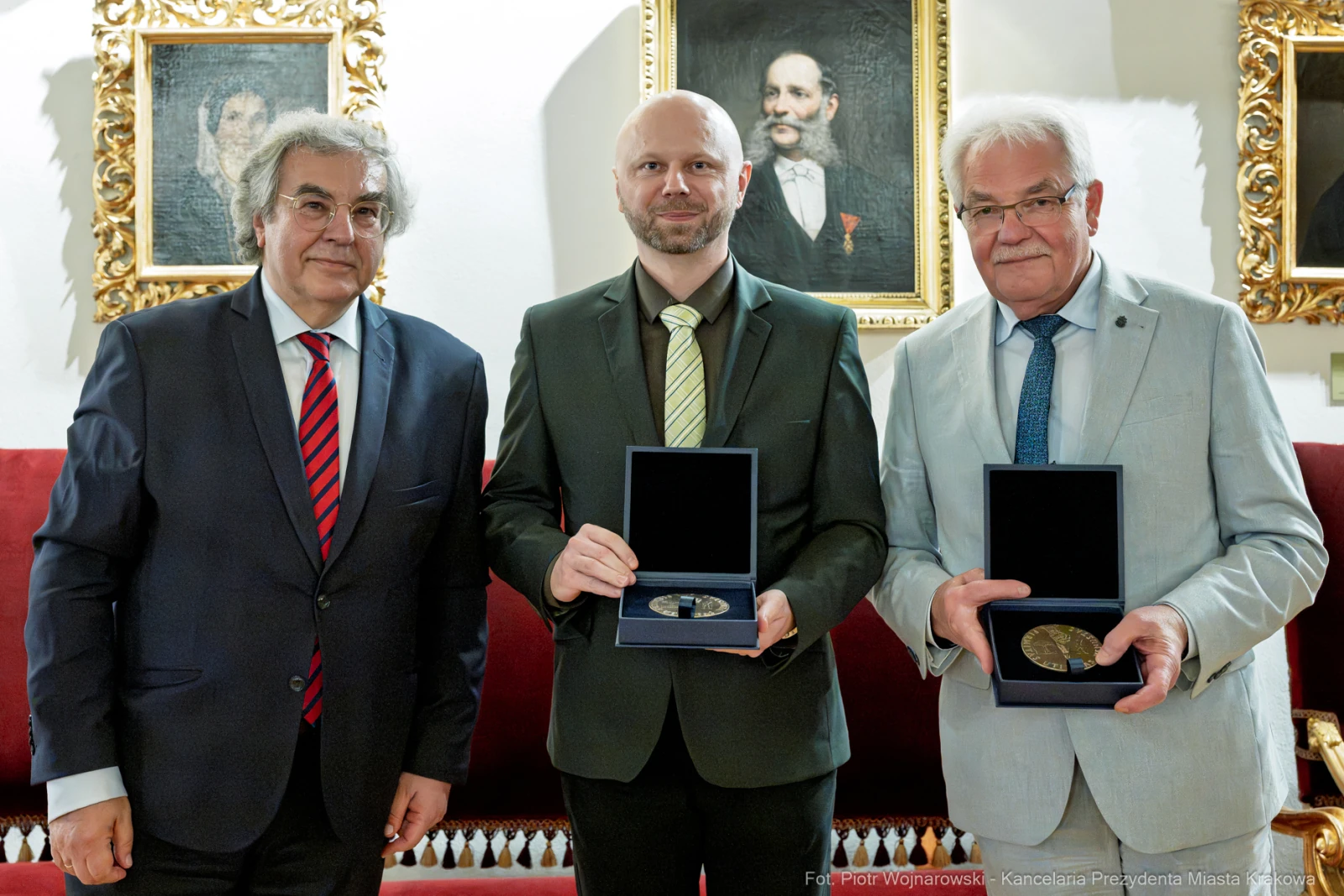 Trzej mężczyźni trzymają medale w eleganckim wnętrzu.  Autor: Piotr Wojnarowski