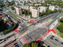 Widok na skrzyżowanie z nowoczesną infrastrukturą drogową i zielenią w otoczeniu.