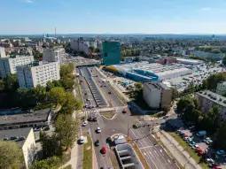 Widok na skrzyżowanie dróg w mieście z budynkami i parkingiem.