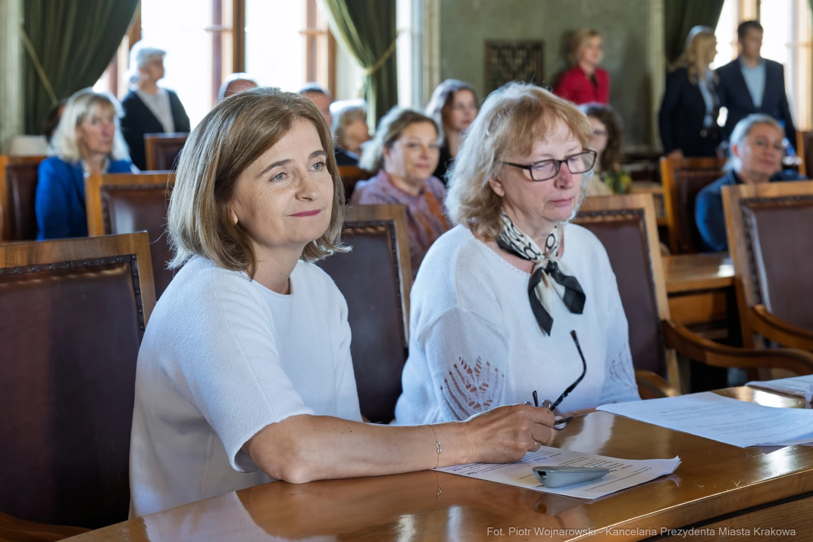 Dwie kobiety siedzące przy stole, uczestniczące w spotkaniu w sali konferencyjnej.  Autor: Piotr Wojnarowski