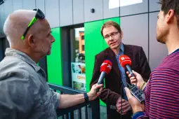 Mężczyzna udziela wywiadu dziennikarzom, trzymając mikrofon.