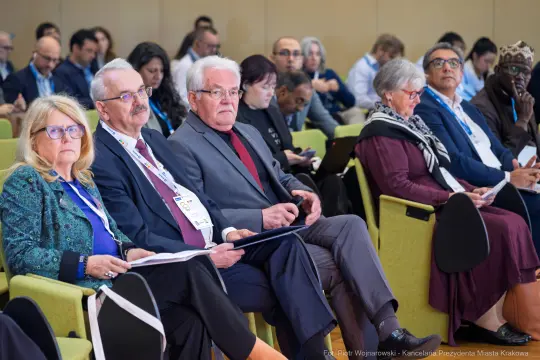 Grupa osób siedzących na konferencji, skupionych na prelekcji.