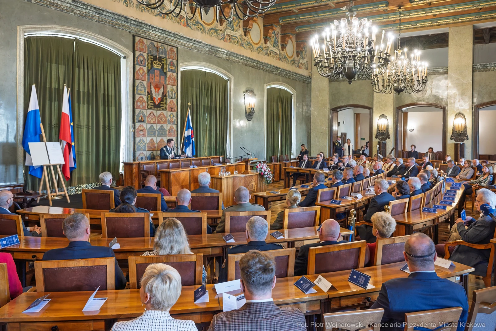 Spotkanie w sali obrad z flagami Rosji i Polski, uczestnicy w formalnych strojach.  Autor: Piotr Wojnarowski