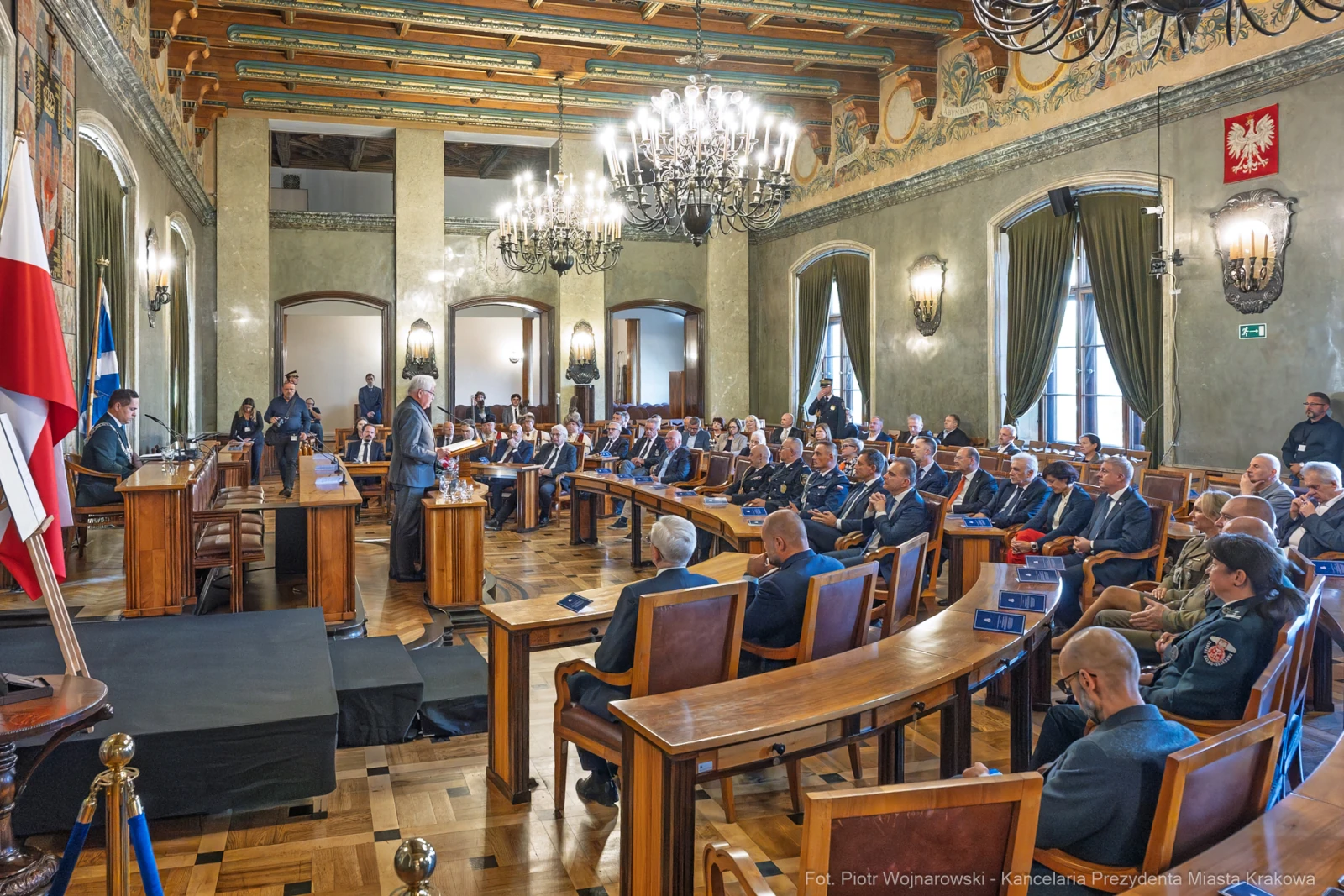 Uroczystość w sali obrad z uczestnikami w garniturach i mundurach.  Autor: Piotr Wojnarowski