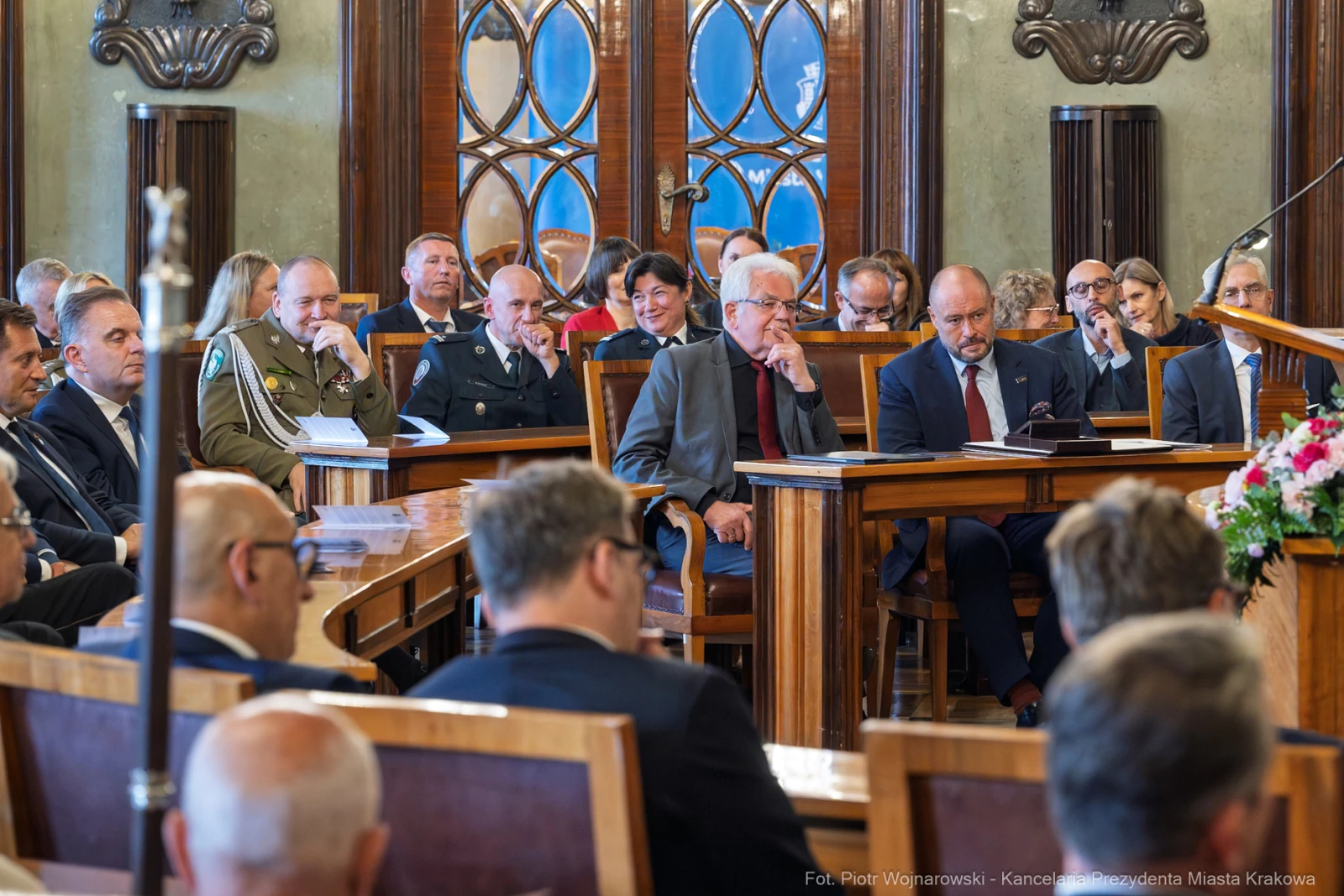 Grupa ludzi w sali obrad, niektórzy w mundurach, inni w garniturach, w trakcie dyskusji.  Autor: Piotr Wojnarowski