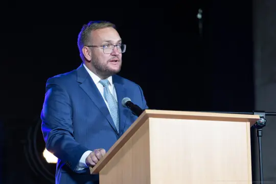 Mężczyzna w garniturze przemawia z mównicy.